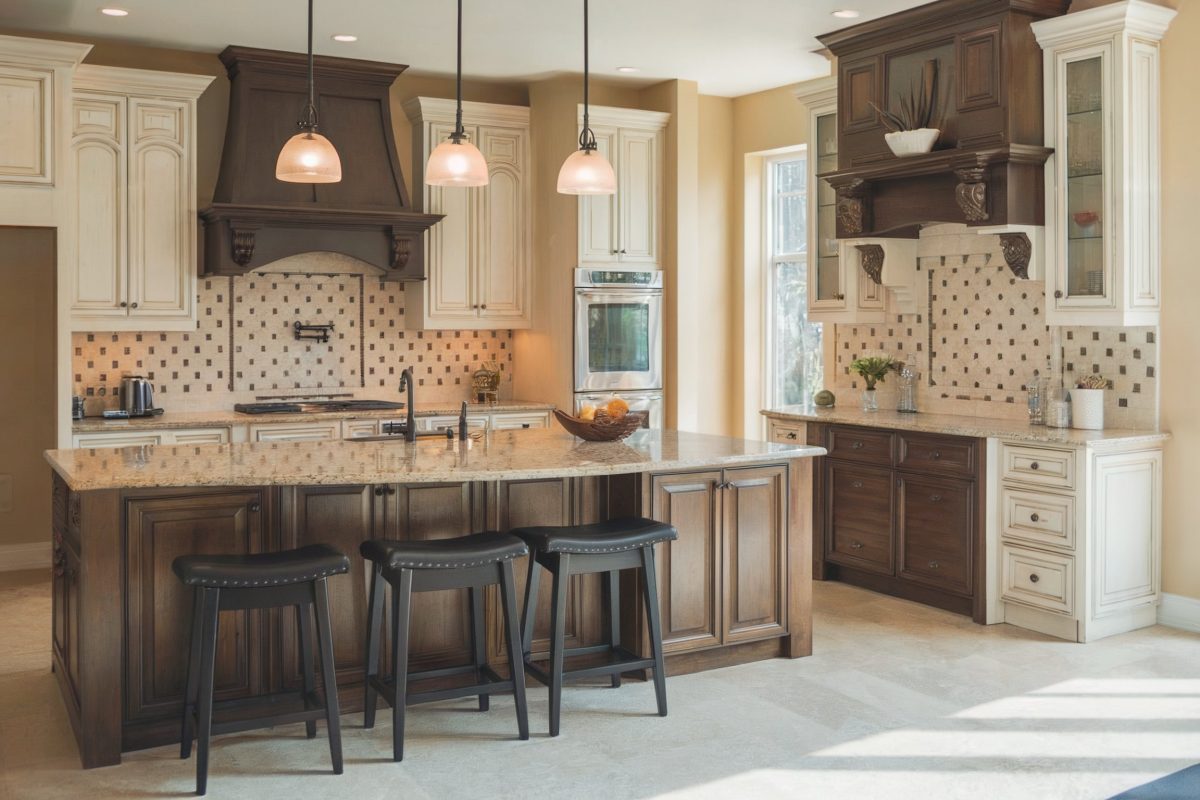 Kitchen with dark wood and cream cabinets, granite countertops, and a central island